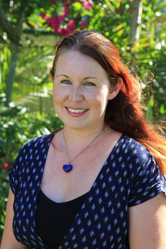 Carly Wilson, director of Rubber Jellyfish, photographed outdoors in front of tropical greenery.